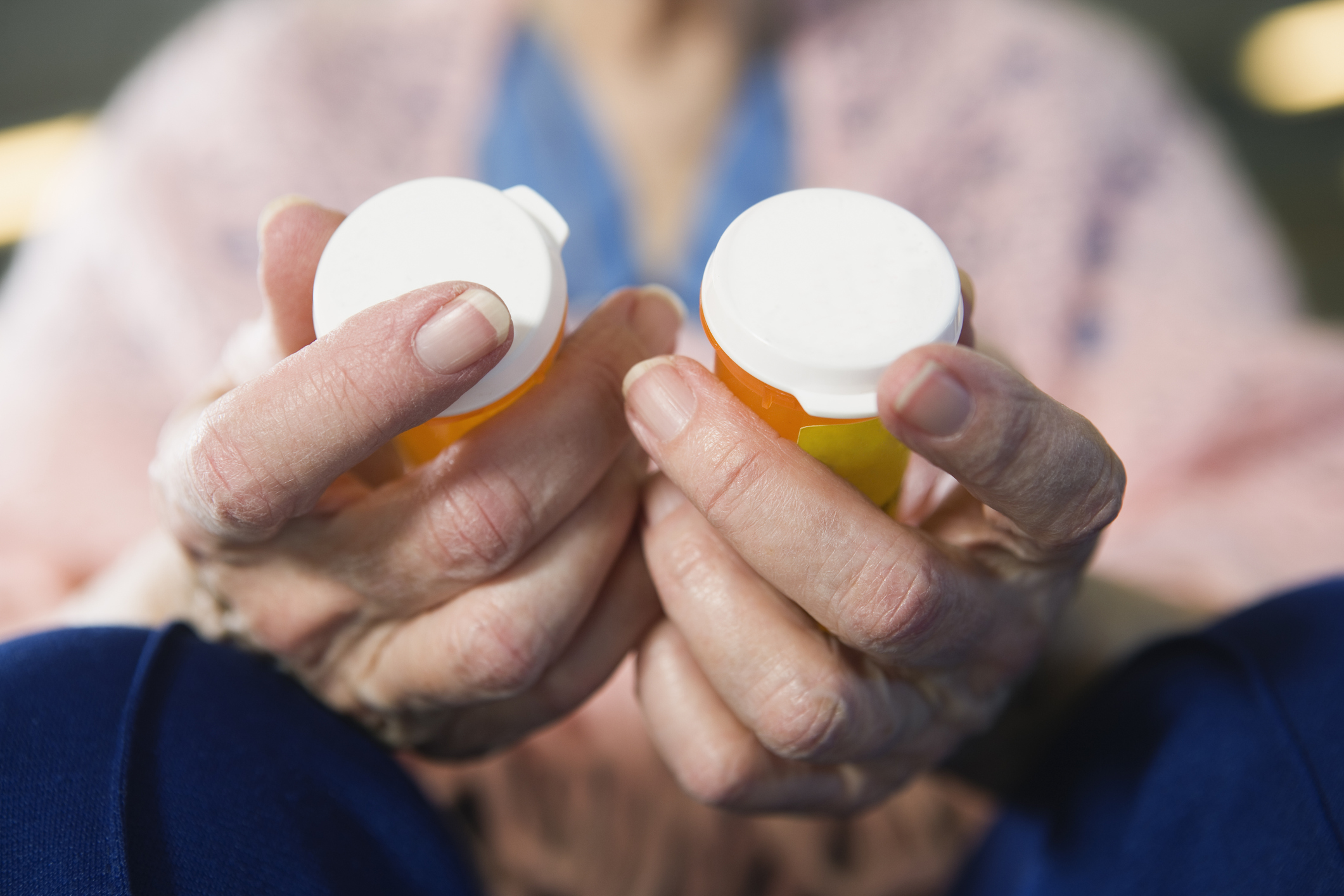 Woman holding two pill bottles